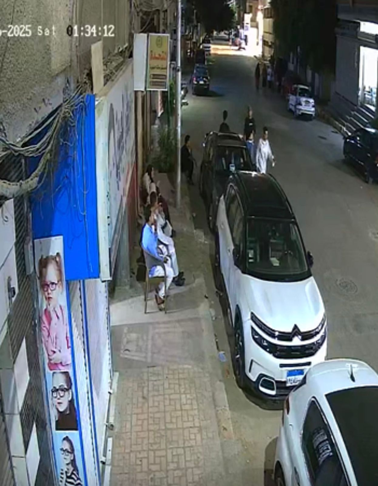 صورة ترصد المشكو وأخرين يجلسون بمدخل بيت الشاكية انتظارا لها ومحاولة الإضرار بها